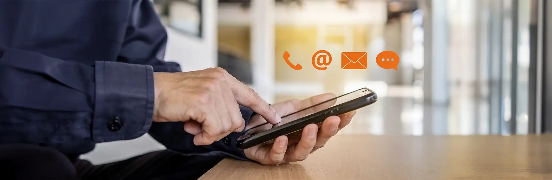close up with a man on his cell phone with orange media icons above